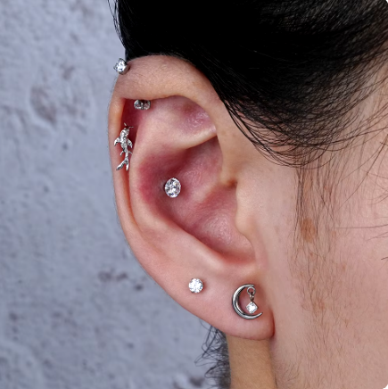 Vrouw die een maan conch piercing met zirkonia draagt.