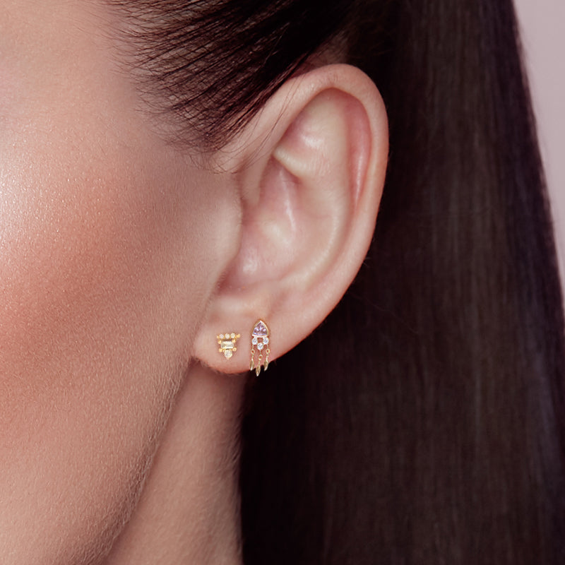 De Bohemian Marika Oorpiercing gedragen, tonend zijn visuele aantrekkingskracht op de lila gekleurde oor helix piercing