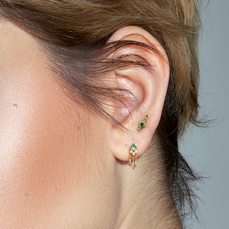 Close-up van de Bohemian Marika Oorpiercing, onthullend zijn voortreffelijk smaragd gekleurd ontwerp."
