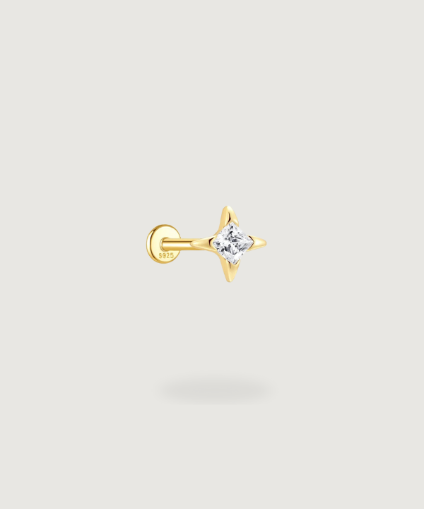 Carmen Tragus-Piercing met elegante marquise-zirkonen op een gouden achtergrond