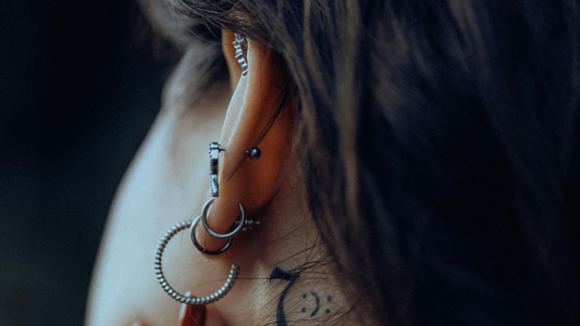 vrouw met verschillende oorpiercings