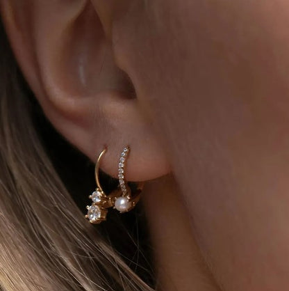 creoolvormige piercing met zirkonen en een mooie parel gedragen op een vrouw