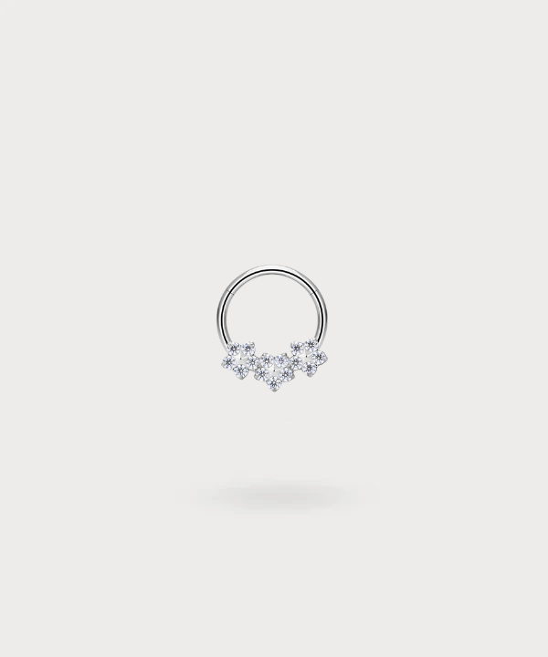 "Piercing Ring Olaya in titanium, zilverkleurig, met drie delicate bloemen ingelegd met zirkonen."